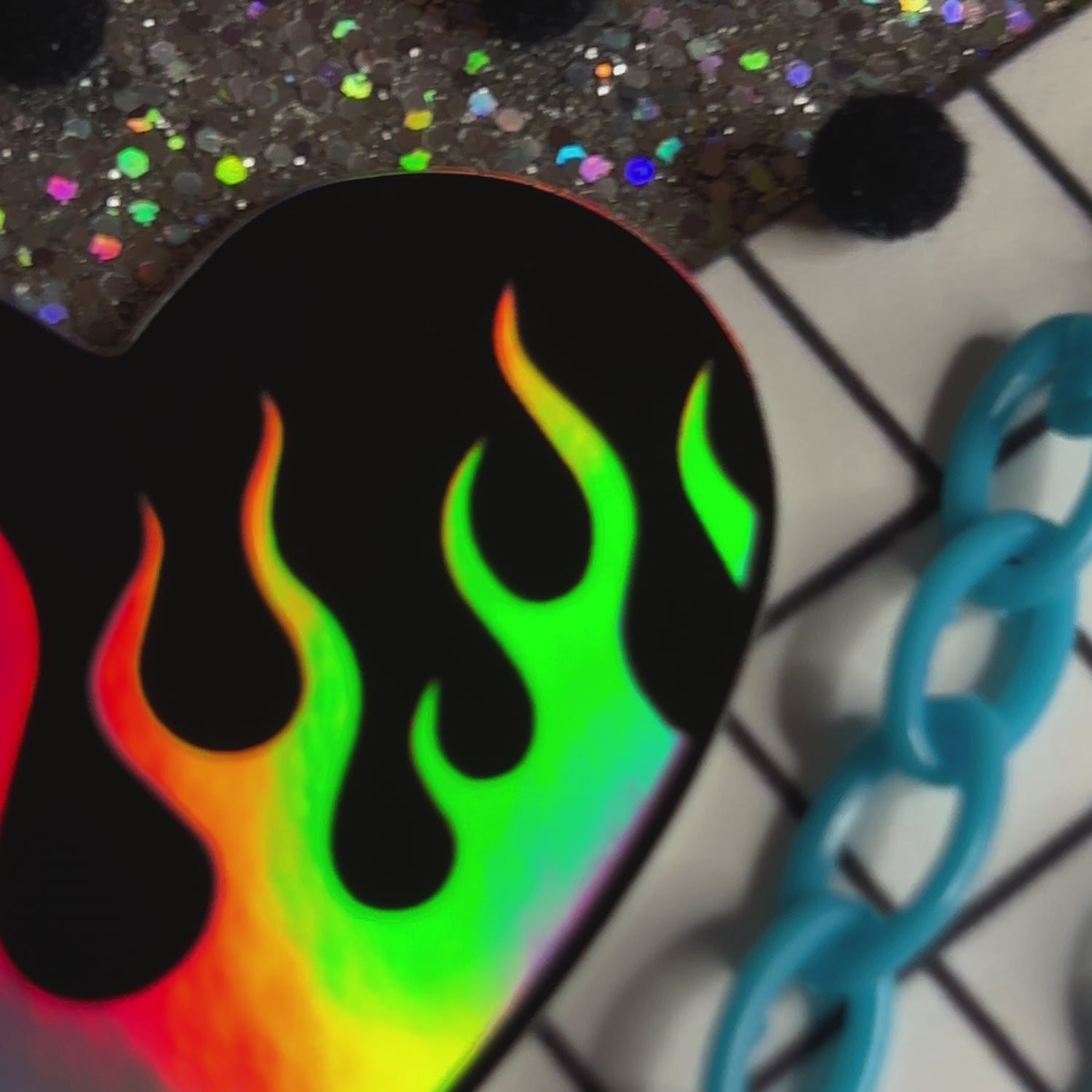 Video of a black heart shaped sticker with holographic flames