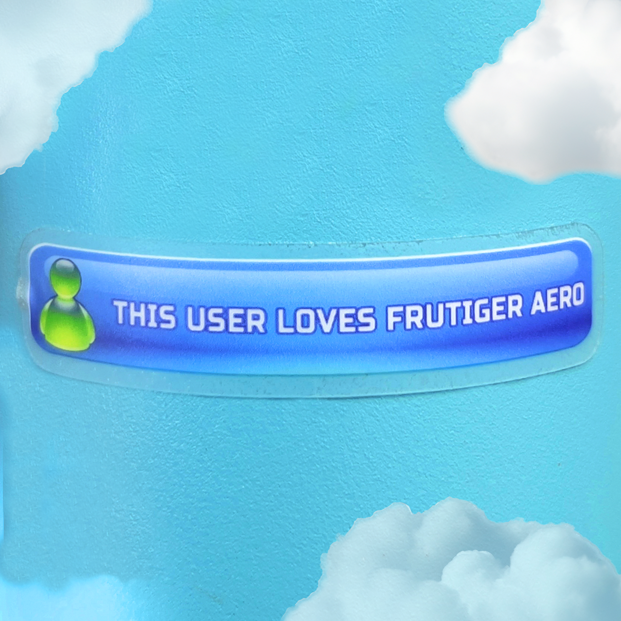 Clear sticker of a blue button that says 'This user loves Frutiger Aero' against a blue sky background