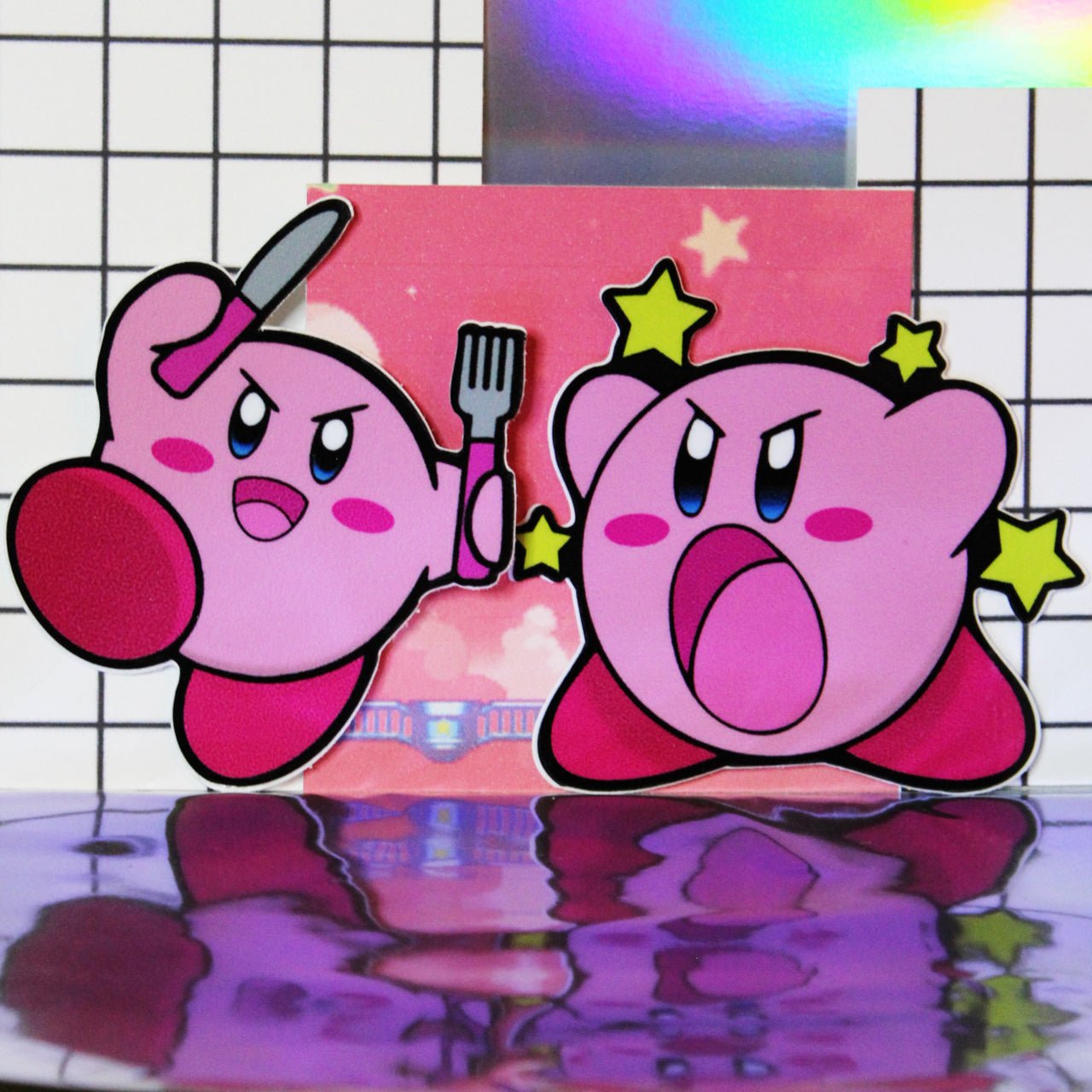 Kirby on left holding knife and fork, Kirby on right has yellow stars in background, both come in one pack