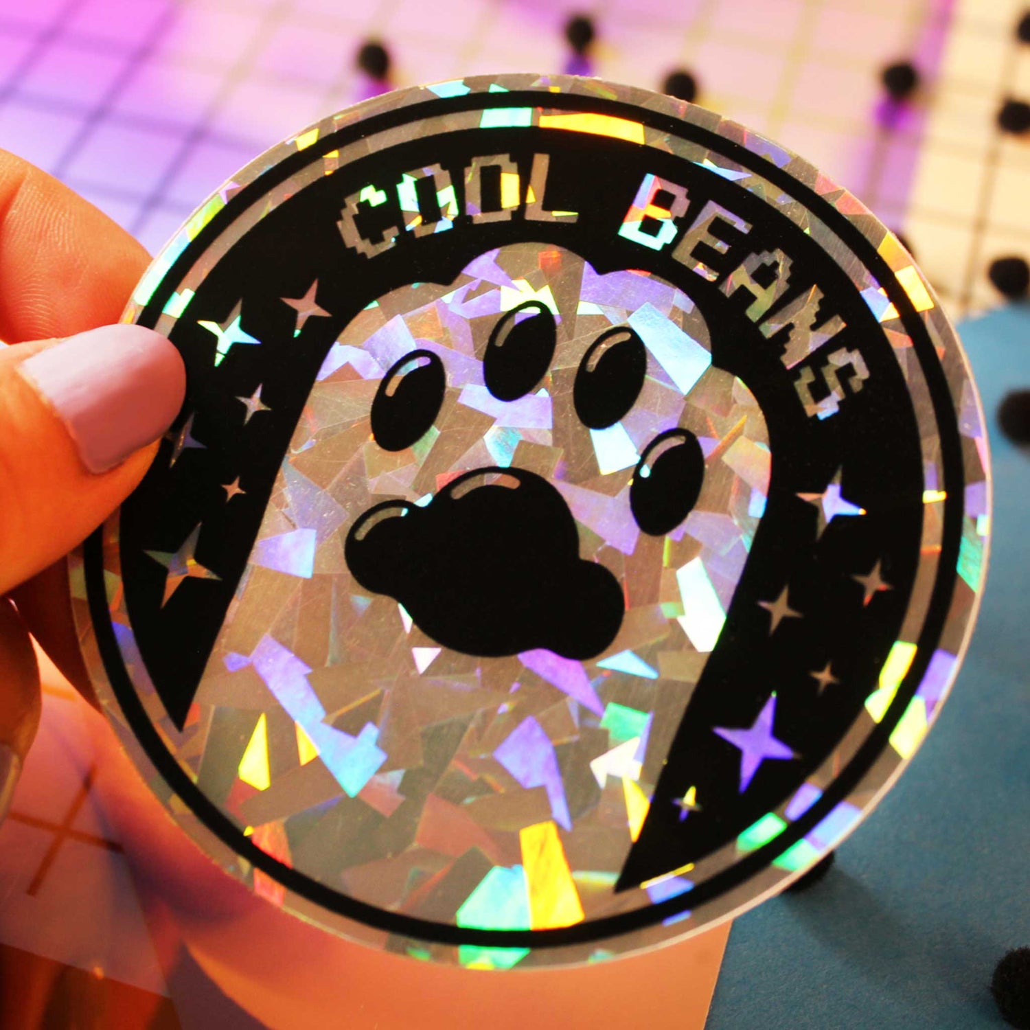 cool beans holographic cat sticker with a paw on it